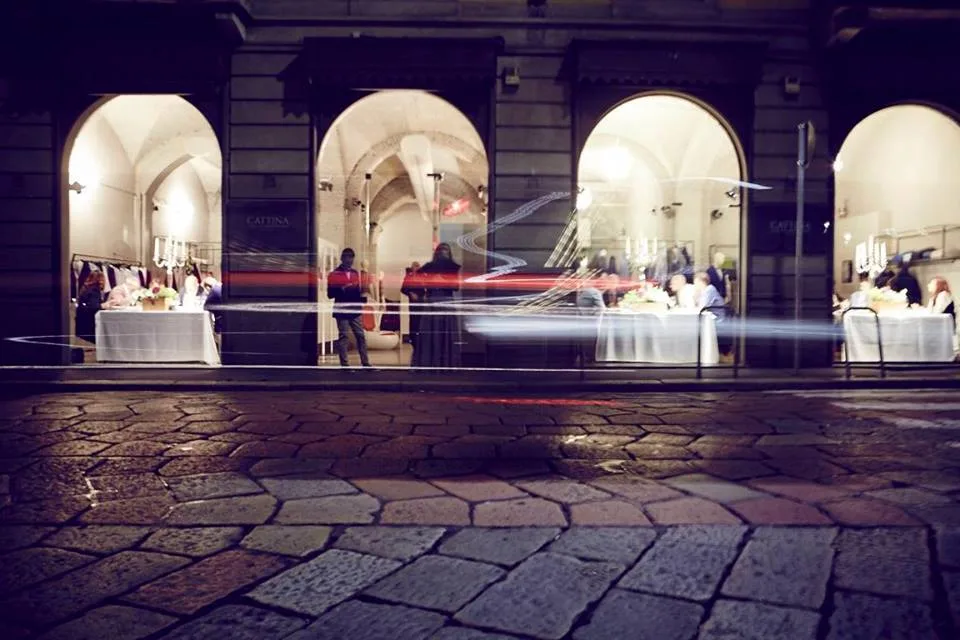 Scatto notturno con luci in movimento sotto i portici durante l'allestimento