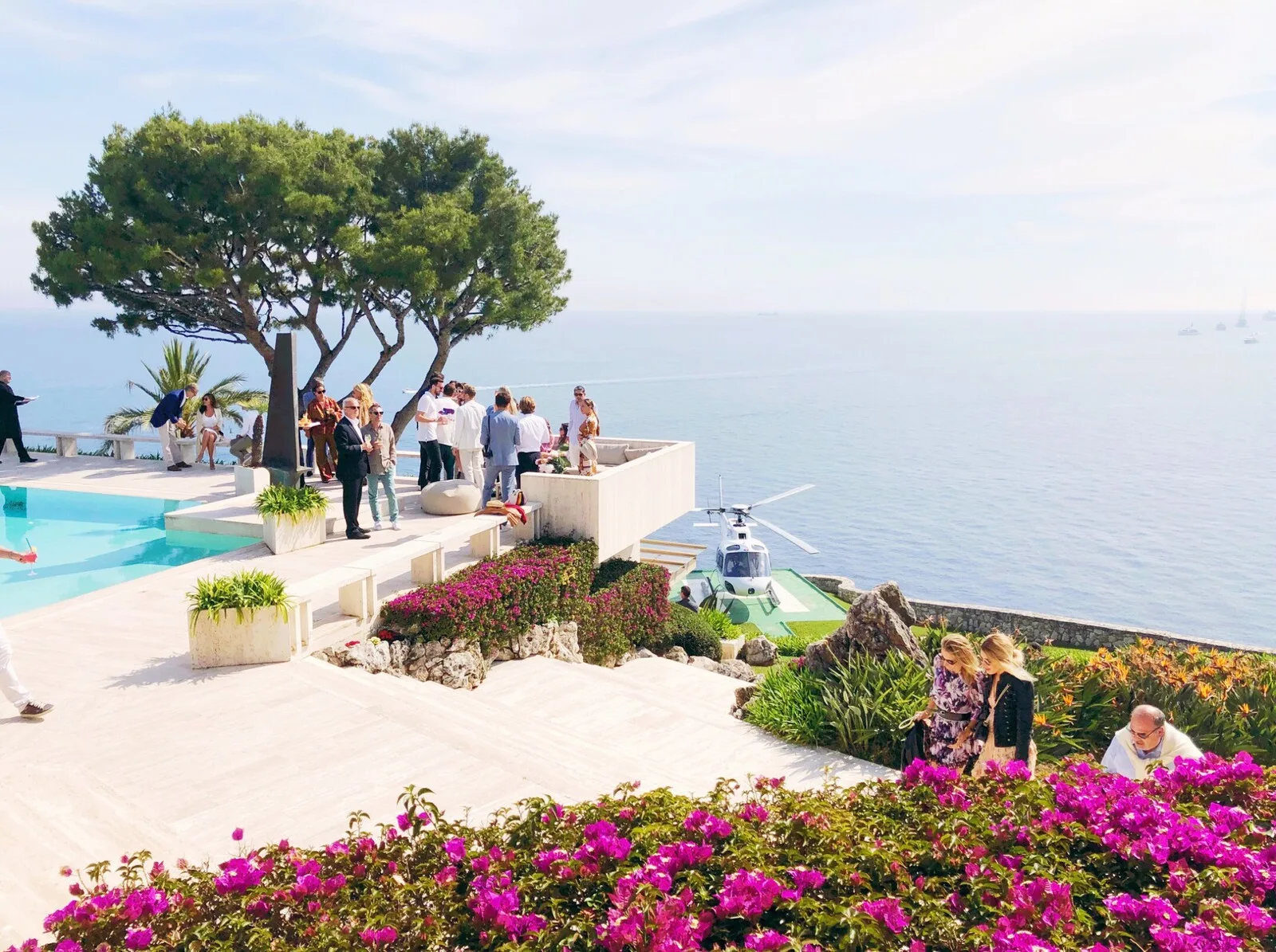 Ospiti in terrazza sul mare con elicottero atterrato accanto ai fiori