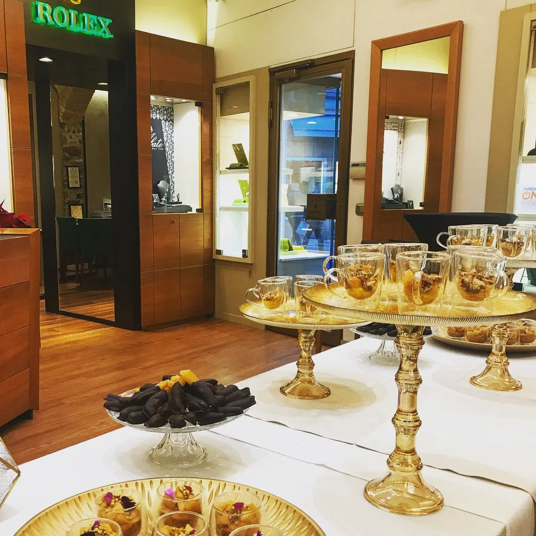 Tavolo di dolcetti su alzatine dorate per un evento in boutique