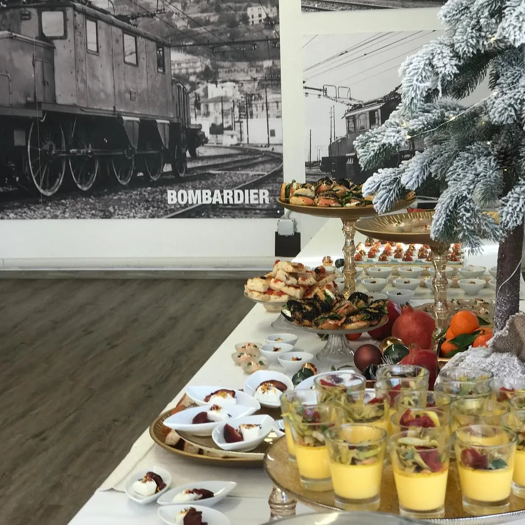 Buffet di finger food su alzatine dorate con decorazioni natalizie