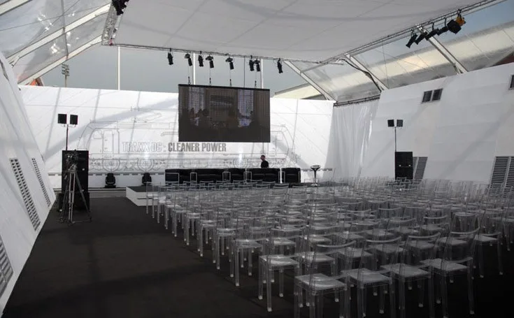 Sala conferenze allestita con sedute trasparenti e schermo a led