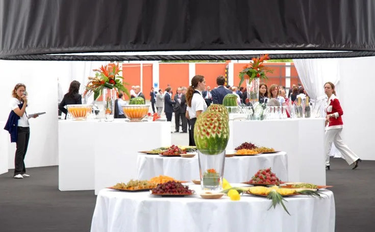 Tavoli bianchi con frutta intagliata e finger food per il coffee break