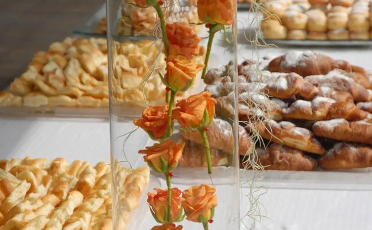 Buffet di dolci e sfogliatine decorato con rose arancioni