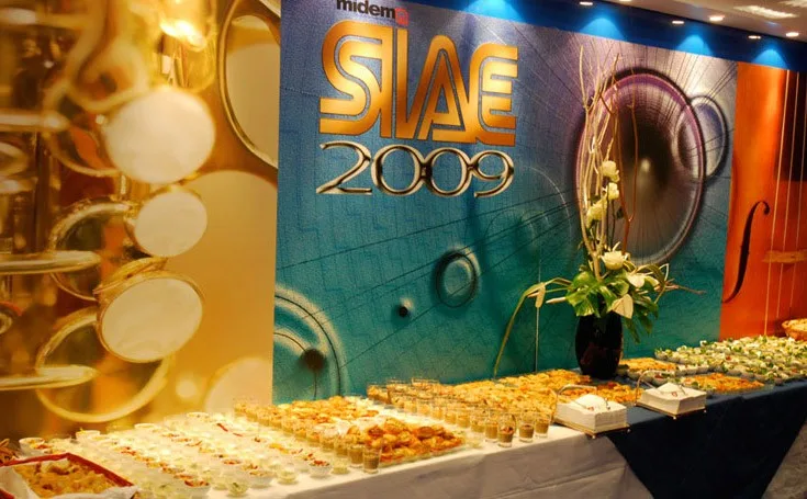 Tavolo di finger food davanti al backdrop dell'evento Siae 2009