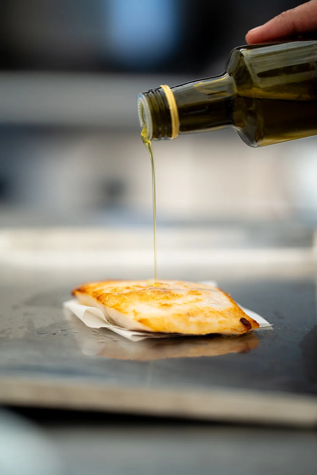 Olio extravergine versato su un trancio di pesce appena cotto