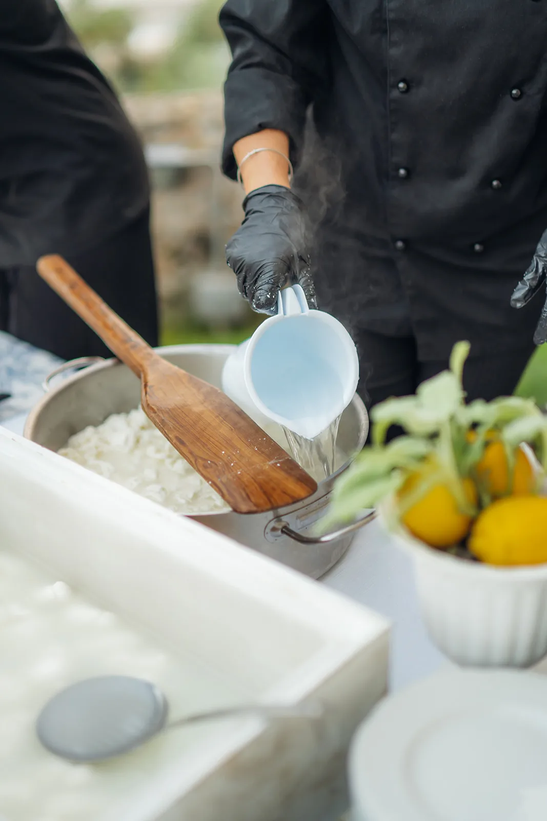 Brodo versato in pentola per la mantecatura del risotto all'aperto