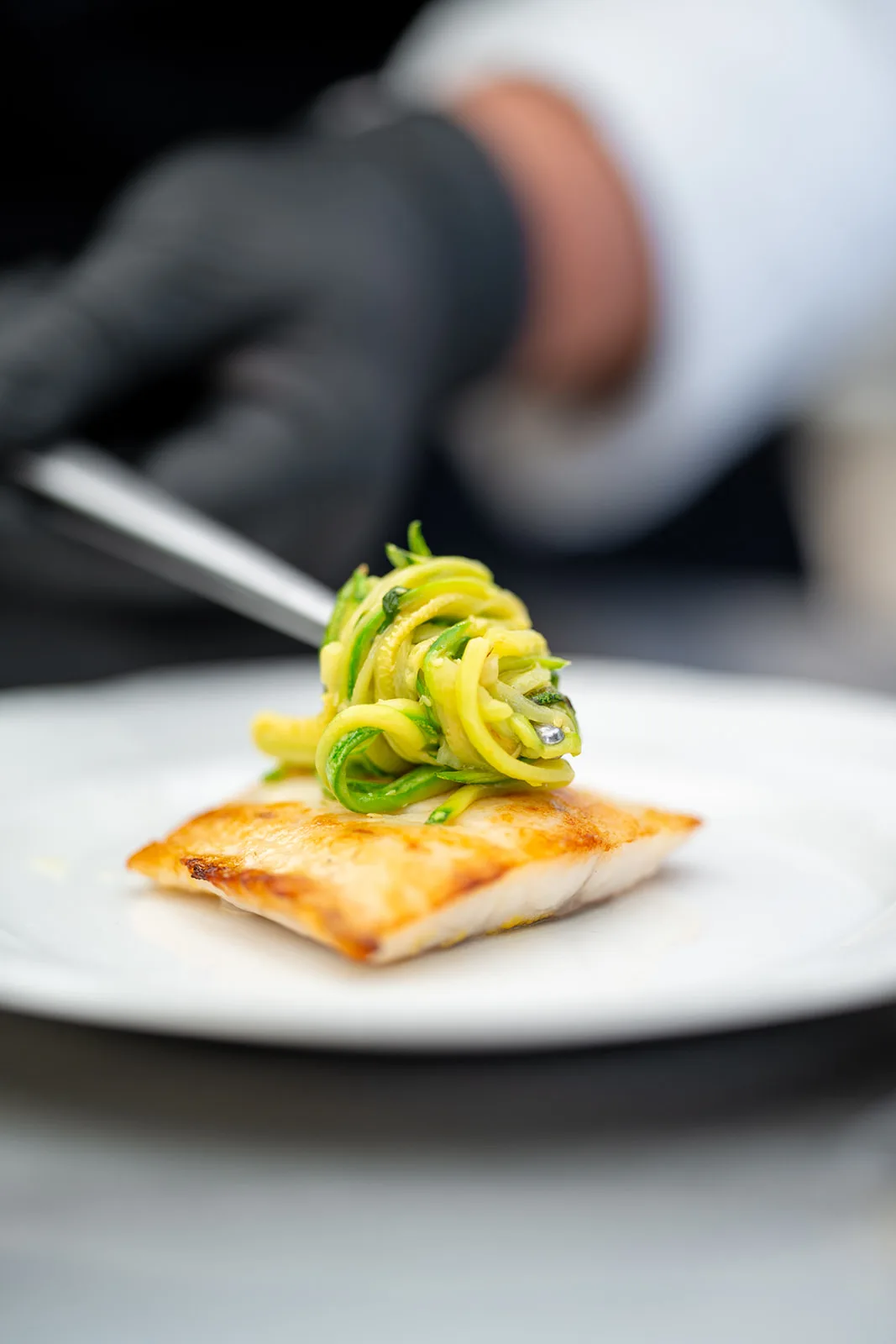 filetto di pesce scottato con nido di zucchine servito al tavolo