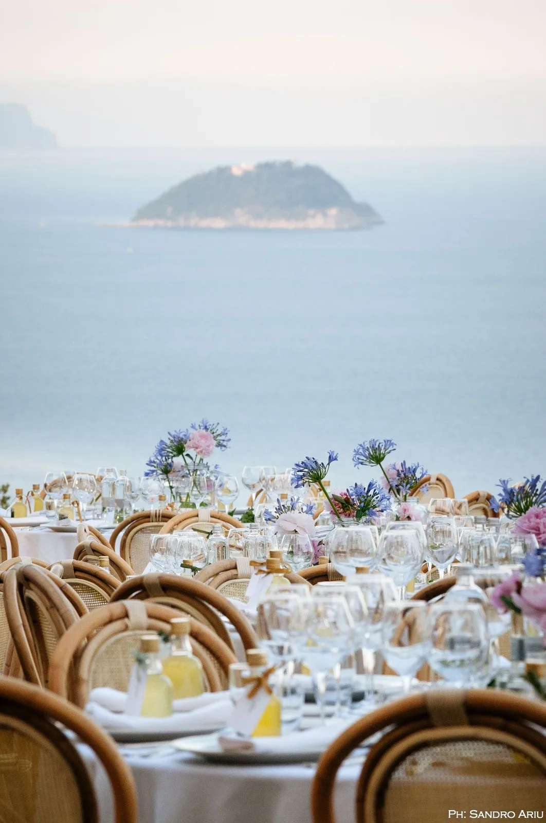 tavolo apparecchiato con vista sull'isola e il mare della Riviera