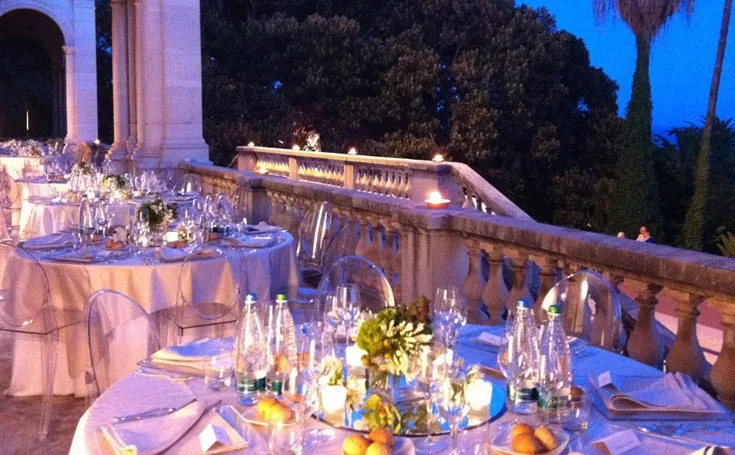 Tavolo imperiale su terrazza illuminato da candele al tramonto