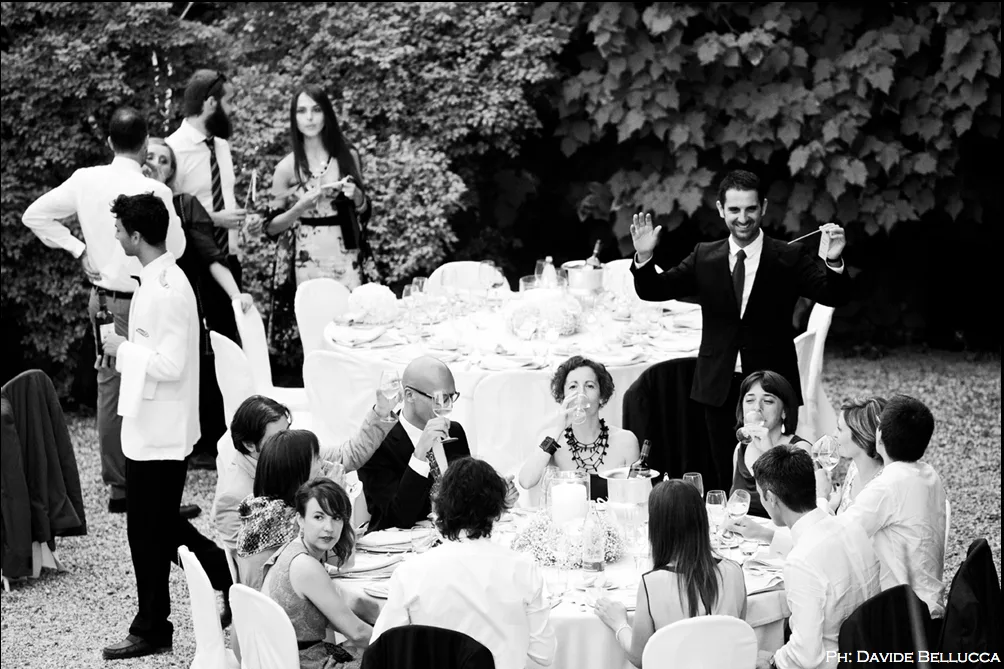 Ospiti brindano a tavola in giardino, scatto in bianco e nero