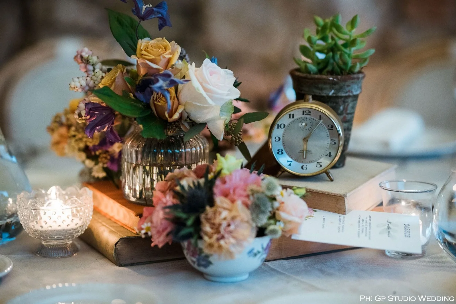 Composizioni di rose e fiori accanto a un orologio vintage