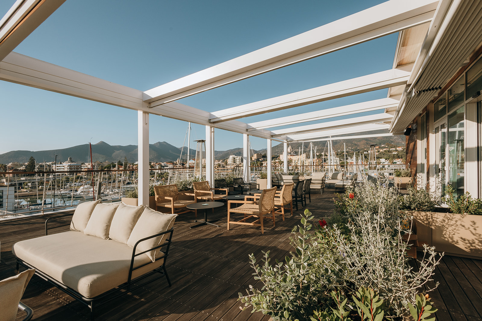 Terrazza panoramica con poltrone in rattan e vista sul porto
