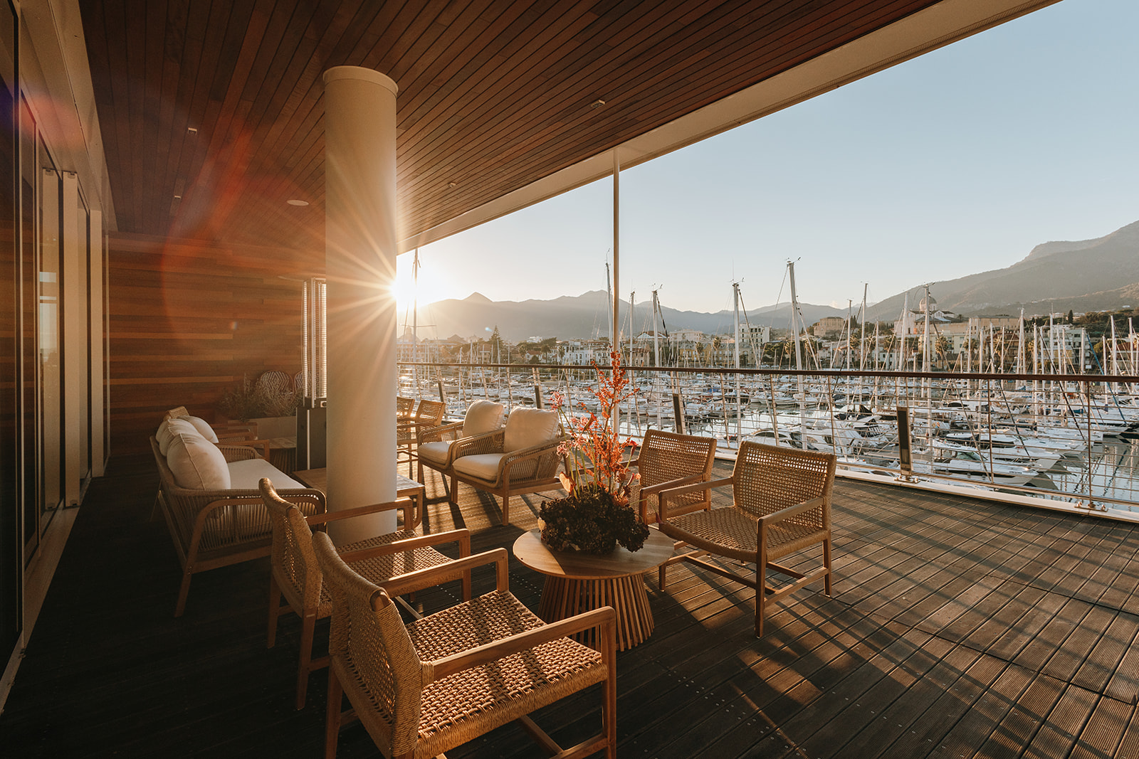 Angolo lounge con poltrone intrecciate illuminato dal sole al tramonto