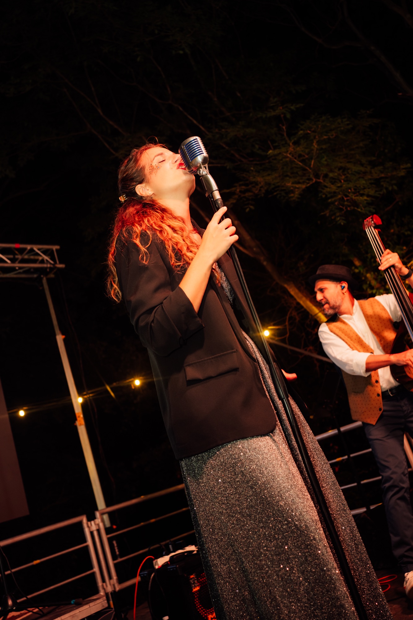 Una cantante si esibisce sul palco accanto al contrabbassista durante la serata