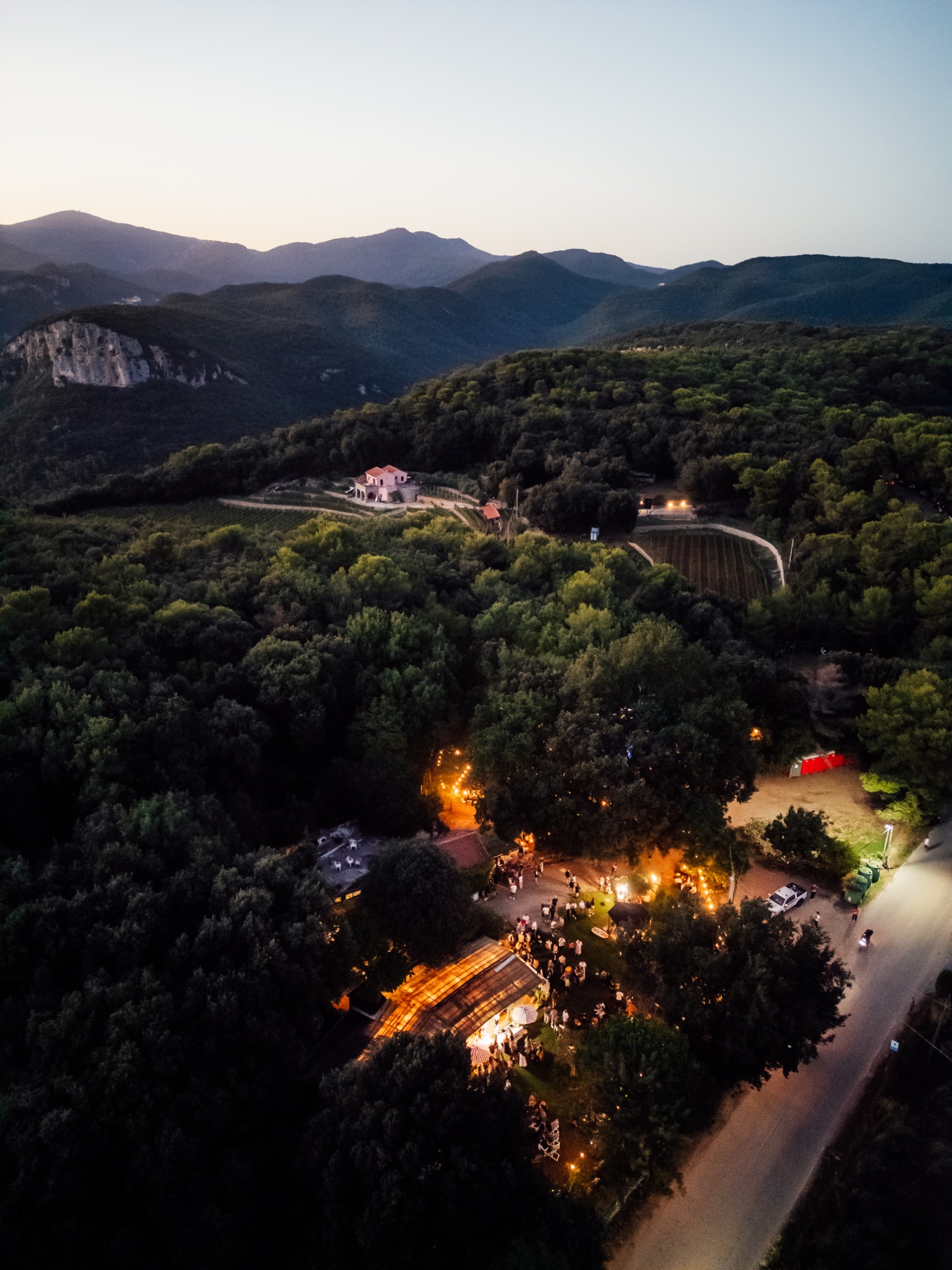 Vista dall'alto della festa tra i boschi dell'Altopiano delle Manie al tramonto